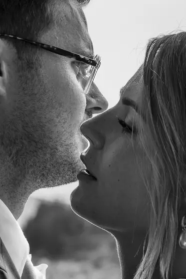 Gros plan en noir et blanc de deux mariés front contre front