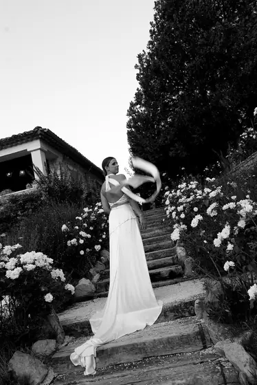 Mariée sur un escalier fleuri, voile emporté par le vent