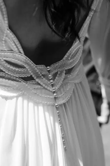 Dos d'une robe de mariée aux boutons gainés, détail de la dentelle