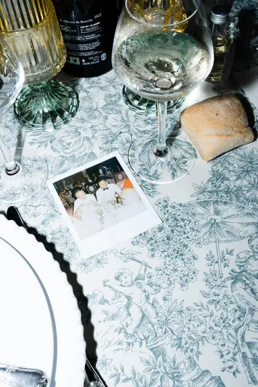 Table dressée avec nappe bleue, verres et photo instantanée