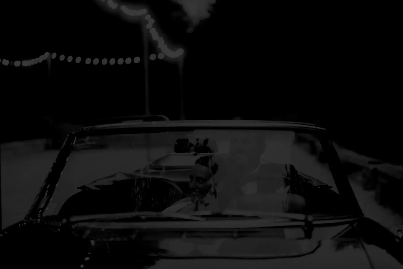 Voiture décapotable de nuit sous les guirlandes