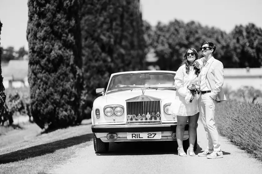 Couple en lunettes de soleil devant une Rolls-Royce blanche