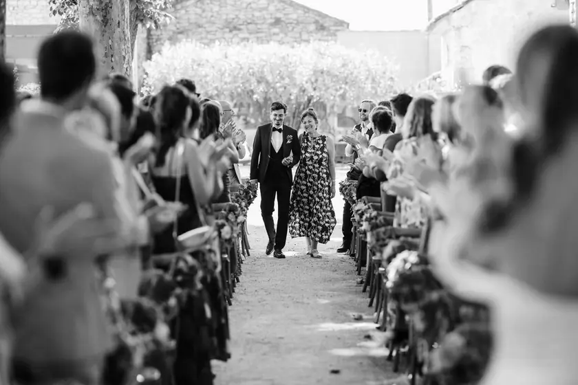 Couple remontant l'allée d'une cérémonie entre les invités