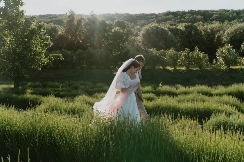 Mariée marchant dans la lavande au soleil couchant