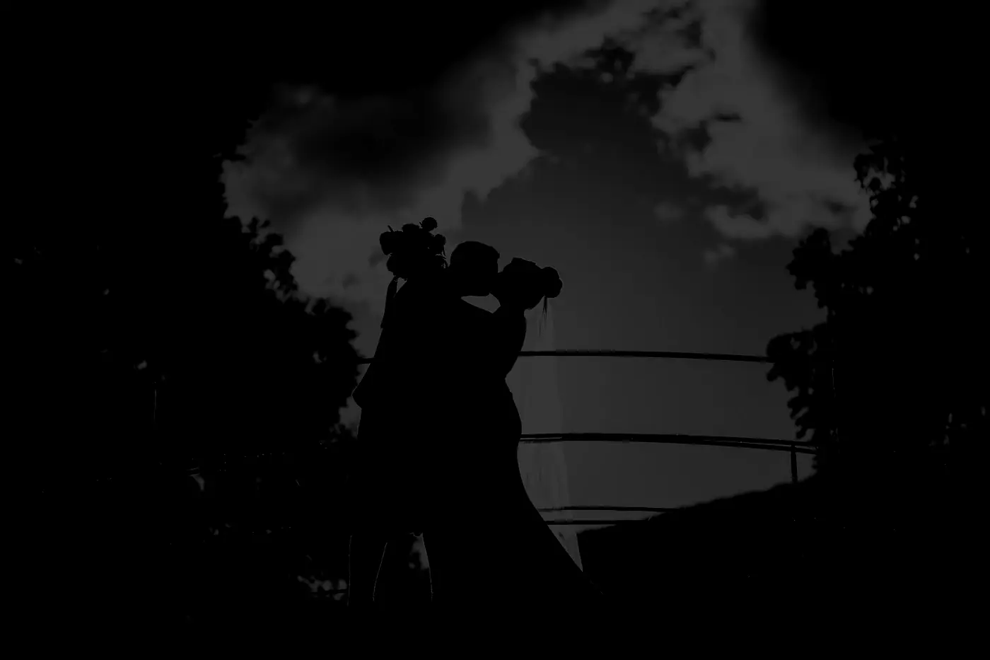 Silhouettes d'un couple sous un ciel d'orage, ombre et lumière