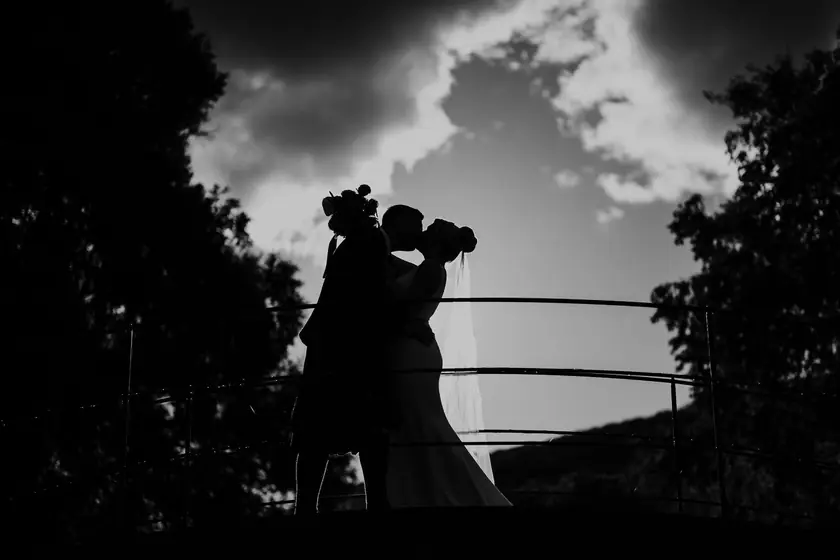 Silhouette d'un couple qui s'embrasse sous un ciel dramatique