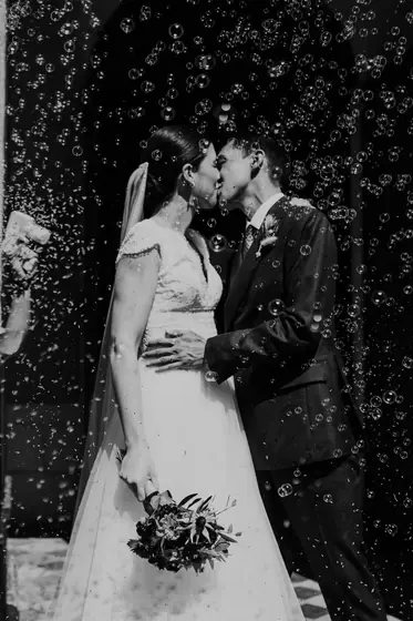 Baiser des mariés sous une pluie de confettis