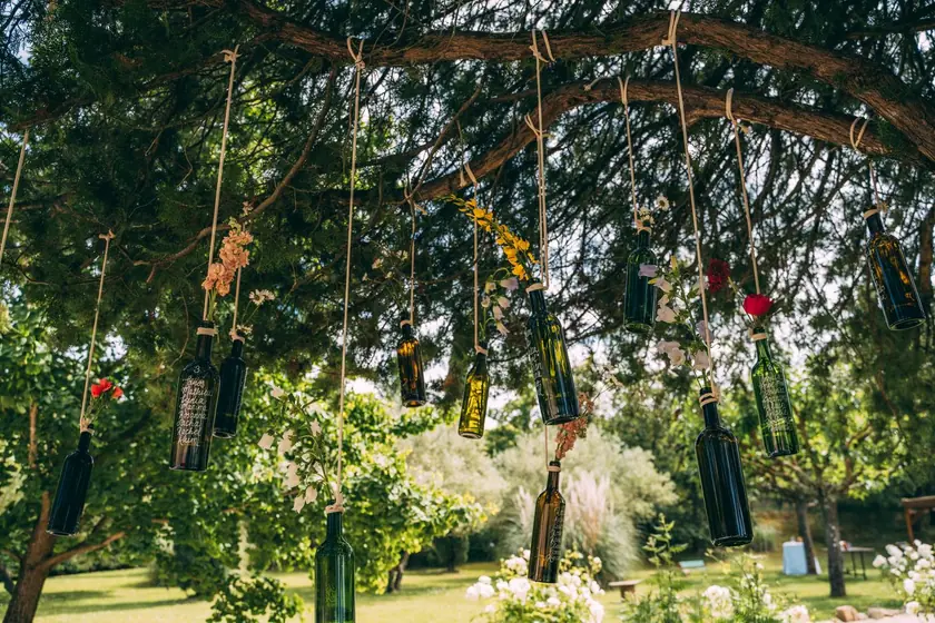 Bouteilles et fleurs suspendues aux branches d'un arbre