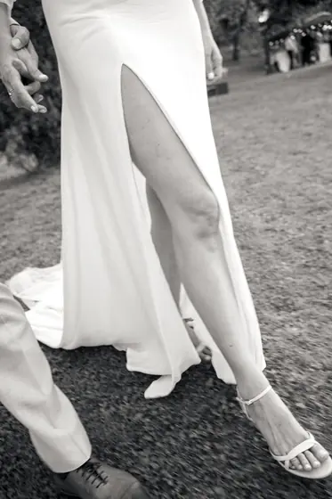 Robe de mariée fendue et sandales sur du gravier
