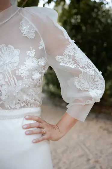 Détail de la dentelle et des manches transparentes d'une robe de mariée