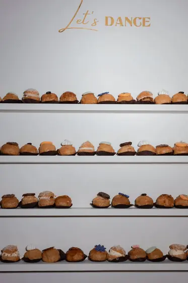 Buffet de choux à la crème sous une enseigne « Let's dance »