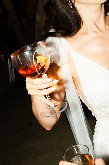 Mariée tenant un verre d'apéritif orange