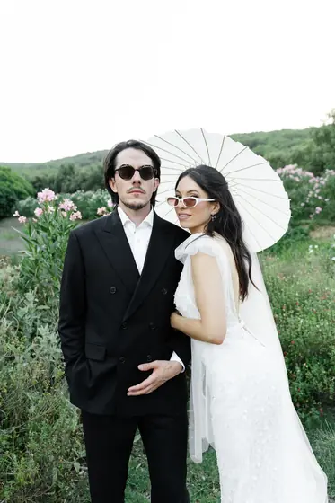 Couple en lunettes de soleil sous une ombrelle blanche