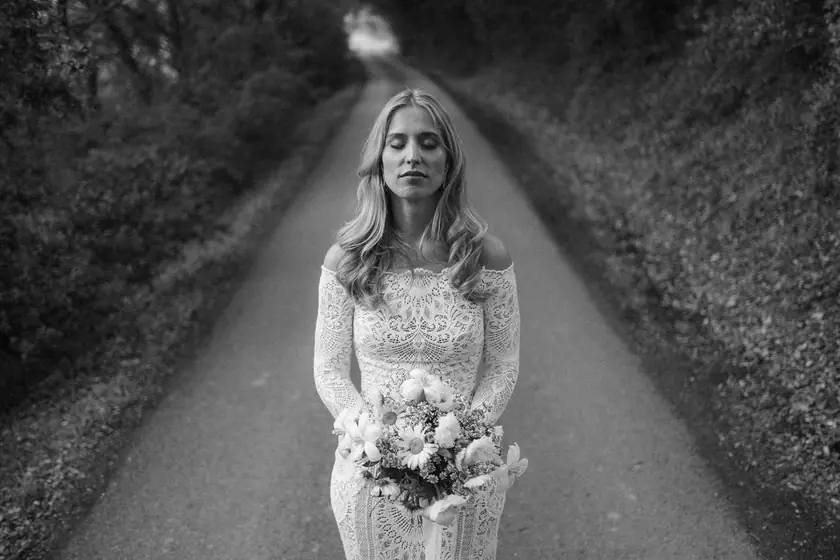 Mariée au bouquet sur un chemin ombragé